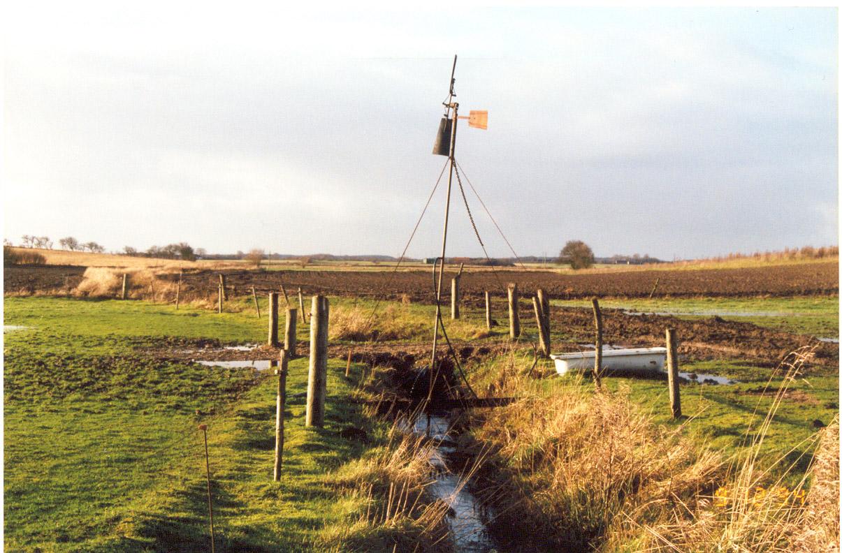 Figur 11. Den vinddrevne vandmølle Af andre muligheder kan nævnes nedgravning af en cement brøndring inde på marken, og forbinde den med et rør der når ud til vandløbet.