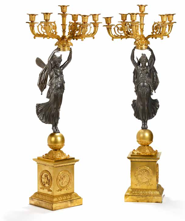 183 A pair of large French gilt and patinated bronze six light candelabra in the manner of Pierre-Philippe Thomire, each with a winged female figure of Victory standing on a sphere holding aloft a