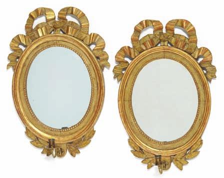 337 337 A pair of gustavian oval giltwood bracket mirrors, each with one brass
