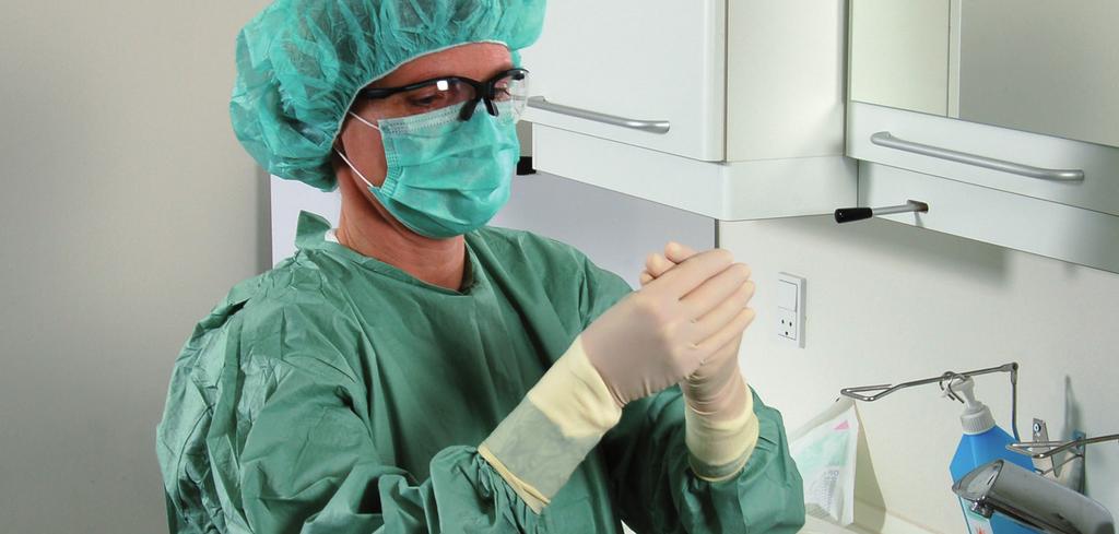 Kapitel 12: Basal kirurgi i mundhulen Figur 4. Tandklinikassistent iført hue, beskyttelsesbriller, mundbind, steril overtrækskittel og sterile handsker.
