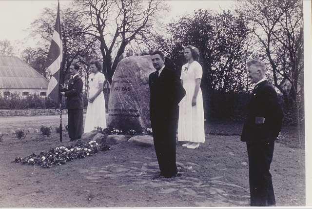 Indvielsen af 5. maj-mindestenen 1945. Fra venstre med fanen Verner Nielsen. Pigerne i hvide konfirmandkjoler er Bitten Sørensen og Anne Lise Jeppesen.