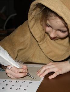 Iført munkehætter prøver eleverne kræfter med at skrive