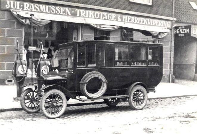 Niels Jacob Nielsens Ford T fotograferet på Algade i Holbæk der hvor Bjørns Isenkram engang lå, men hvor der nu er etableret en Inspiration forretning. Billedet er taget ved rutens åbning i 1922.