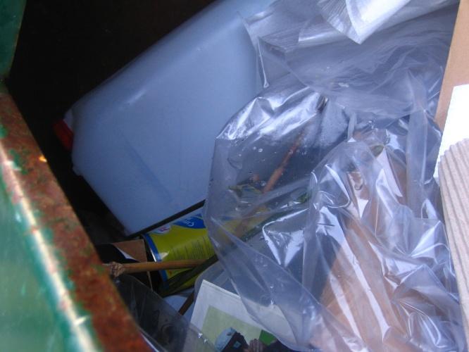 brændbart. Som det kan ses indeholder containeren rigtig meget pap, og der er også en plastdunk og en spraydåse i containeren.