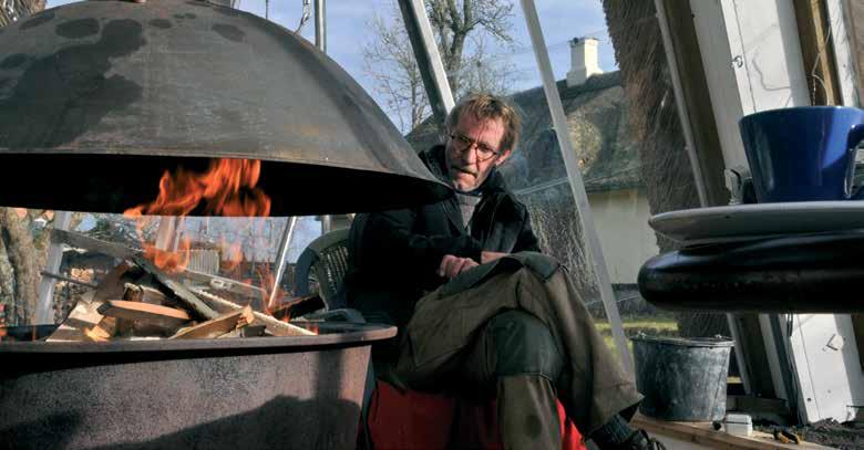 Tusindkunstner og tækkemand Bjarme Johansen nyder at fyre op i det tækkede drivhus, men er endnu ikke færdig med at overveje, om der skal være pejs eller brændeovn.