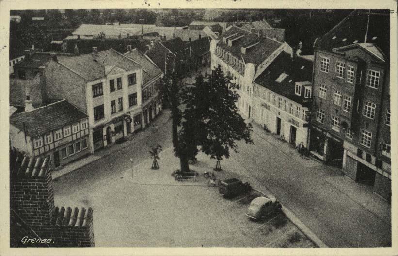 I baggrunden ses Torvet 2-8 med bl.a. Vilhelm Hansens boghandel i nr. 4 og Jernstøbergården i nr. 6. Tryk. Lystryk.