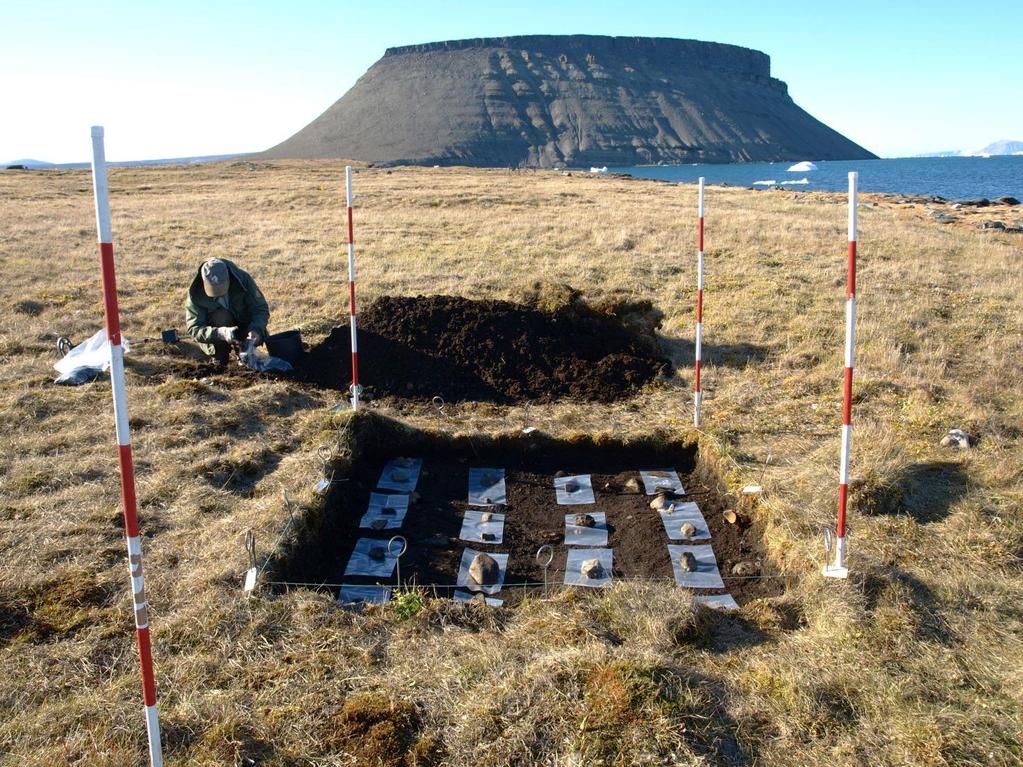 Udgravningen af et prøvefelt i aktivitets- og udsmidsområdet foran Uummannaq Holtved Hus 5. Prøvefeltet set fra ca. nord. BG gennemsøger jordbunker for metal. (Fot. ABG). 4.
