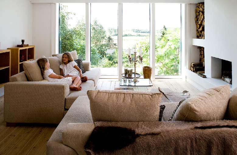 I stuen er der også udsigt til det fri gennem store vinduer. Ilva-sofa, sofabord fra Interstudio og accessories alle fra Munthe plus Simonsen skaber en afslappet indretning.