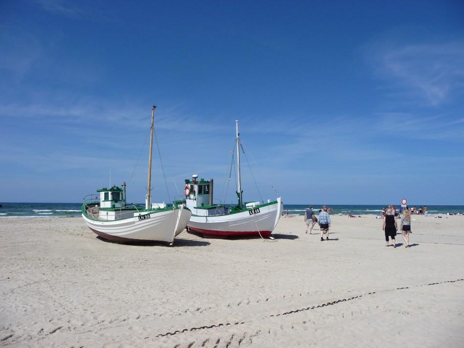 : Løkken strand og moleleje Løkken Strand karakteriseres af de hvide badehuse (om sommeren), fiskekutterne og molen.