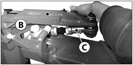 Tag den hydrauliske cylinderarm (A) ud af over-center fast armen (B) - fjern bolten. 3. Træk stopskruen (D) tilbage. Løsn også kontramøtrikkerne på justérarmen (C). 4.
