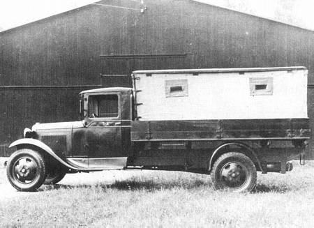 Lastvogn af typen Ford A 1937 A). Radioautomobilet medfører: - 1 SMA-station Stationen betjenes af 1 fører og 6 mand (3 telegrafister og 3 motorpassere); oprettes på ca. 15 min. og nedbrydes på ca.