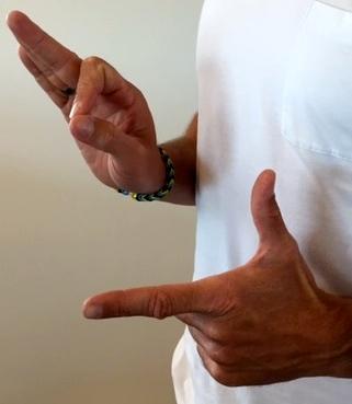 De andre fingre er knyttet Venstre hånds tommel- og pegefinger griber