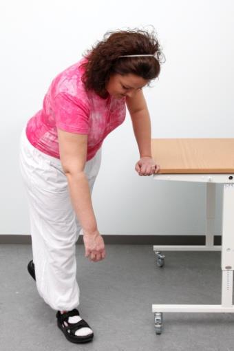 Øvelse 5 Støt dig til et bord eller en stol med den raske arm. Stå med fødderne forskudt.