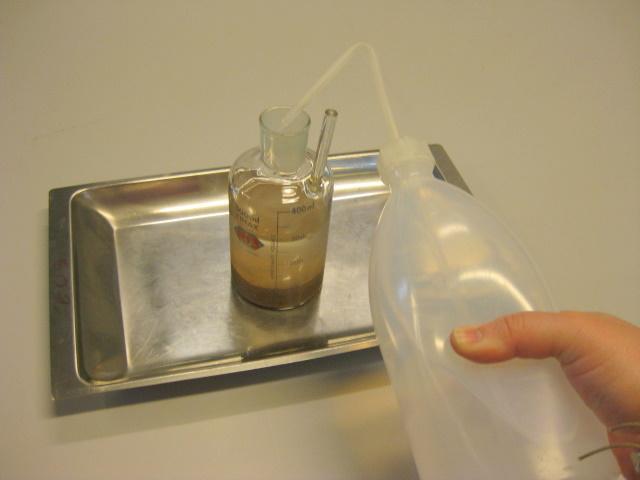 Figur 4: Pyknometeret fylde forigtigt op med demineralieret vand. Vandet løber lang inderiden af pyknometeret.