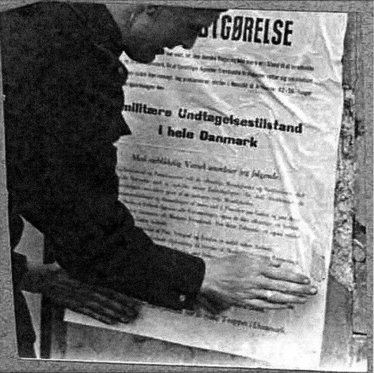 Et føl (dansk betjent) klæber tysk plakat op. Da tyskerne d. 19 september 1944 anbragte det danske politi i deres KZlejre, måtte de selv gøre arbejdet.