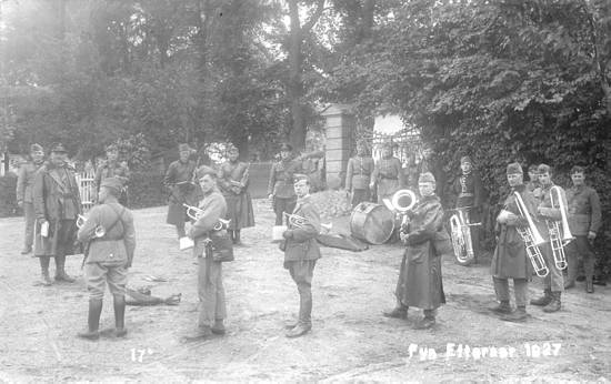 Et fodfolksmusikkorps, måske 6. Regiments musikkorps, fotograferet under en koncert i en fynsk landsby, efteråret 1927. Kortet er dateret 5. oktober 1927.