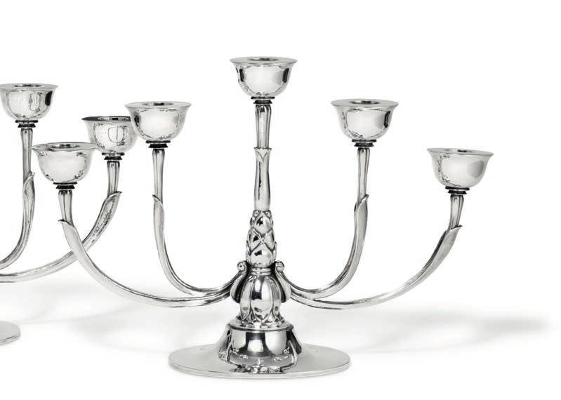 1129 1129 HARALD NIELSEN b. Baarse 1892, d. 1977 A pair of five-branch hammered sterling silver candelabra. Centre with cone-shaped leaf ornamentation. Oval bases. Georg Jensen 1933-1944. Design no.