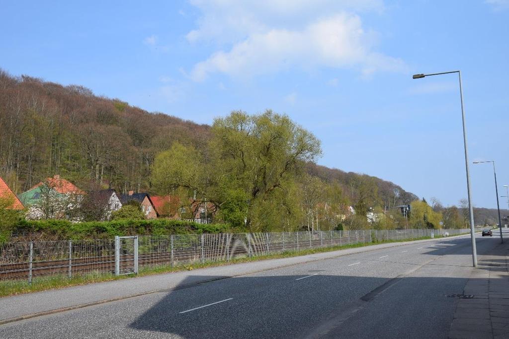 Figur 13: Udsigt fra Rødkildevej i Vejle over banen. Banen forløber her i terræn og fremstår ikke markant. Der er boliger tæt på banen.