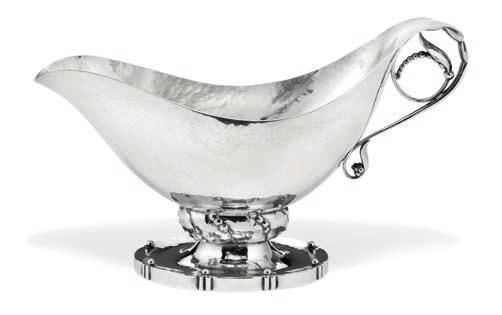 Rådvad 1866, d. Hellerup 1935 Hammered silver sauce boat with stylized leaf ornamentation. Oval base with beads. Georg Jensen 1945-1927. Design no. 177. Weight 338 gr. H. 12,4 cm.