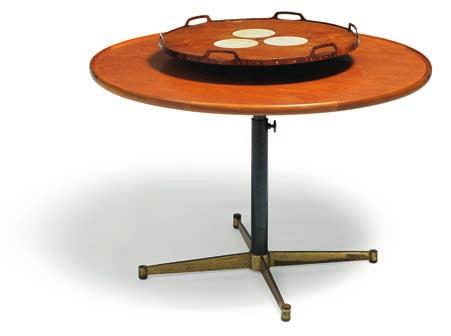 1982 Height adjustable table with anodized metal frame and brass base. Circular teak top with raised edge, center fitted with brass lever to raise loose circular teak tray.