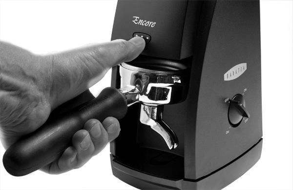 Fjern formalet kaffebeholder og placer espresso kurven inde i kværnen direkte under puls knappen (se billede).