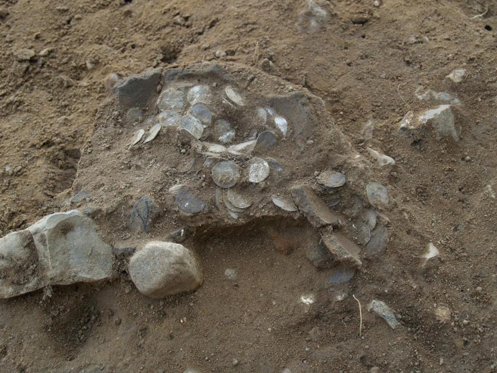 Fig. 6. Bunden af lerkarret X175 med mønterne. Foto Anders Hartvig, Arkæologi Haderslev Skatten Et af formålene ved undersøgelsen var at finde deponeringsstedet, samt en mulig beholder for skatten.