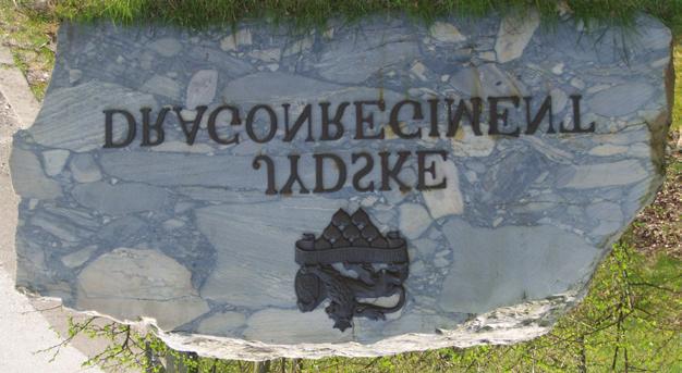 Stenen er fundet i øvelsesområdet, overskåret og forsynet med regimentets mærke og navnetræk.