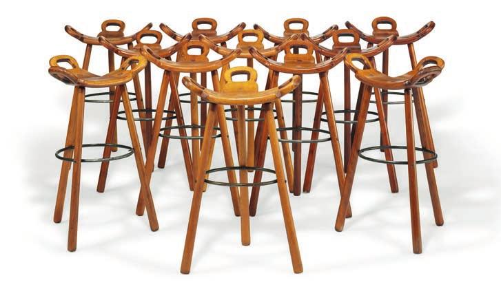 1009 SPANISH DESIGN "Marbella". A set of 12 dark polished beech brutalist bar stools. Three legged frame, saddleshaped seat and "handles". Black lacquered metal foot rest.