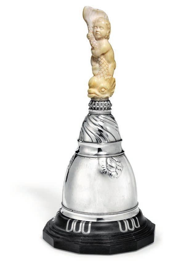 882 GEORG JENSEN b. Rådvad 1866, d. Hellerup 1935 A large hammered silver chairman's bell with ivory handle, carved in the shape of a boy and a fish. On a edged ebony base with silver inlays.