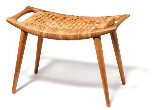 A patinated oak stool on tapering legs. Seat with woven cane. Designed 1954. This example made ca. 1960 by cabinetmaker Johannes Hansen. H. 41 cm. L. 66 cm. W. 38,5 cm.