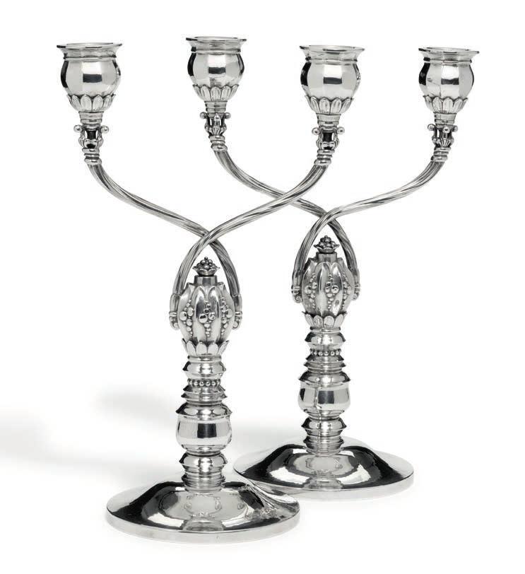 885 885 JOHAN ROHDE b. Randers 1856, d. Hellerup 1935 A pair of two branch sterling silver candelabra. Circular bases, leaves and beads. Georg Jensen 1925-1932. Design no. 343. Total weight 1152 gr.