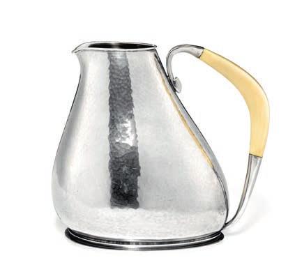 908 CD KARL GUSTAV HANSEN b. Kolding 1914, d. 2002 A hammered sterling silver art déco pitcher. Asymmetrical shape on profiled, oval base with curved ivory handle.