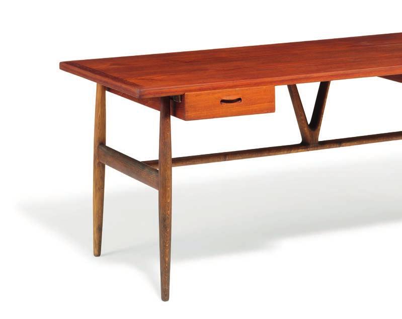 954 954 HANS J. WEGNER b. Tønder 1914, d. Gentofte 2007 "JH 563". Freestanding desk with solid oak frame. Teak top with two drawers in front. Stretcher with V-shape, brass fittings. Designed 1950.