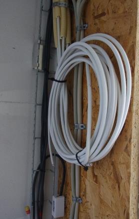 Synlige kabler i teknikskab: Antennekabler trukket i tomrør ud til en eldåse med blænd dæksel i de enkelte rum i boligen.