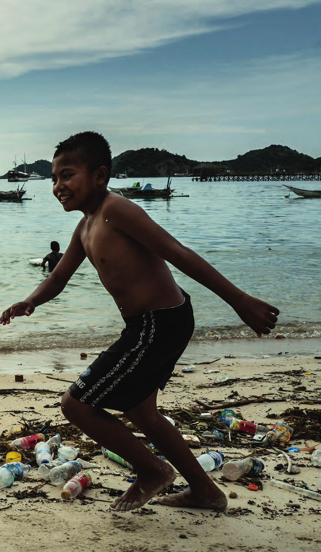 PLASTIC KRYDRET MED VENLIGHED Stranden syd for Labuan Bajo, en lille havneby på den vestligste spids af øen Flores i Indonesien, summer af liv. En flok drenge og deres mor boltrer sig i vandet.