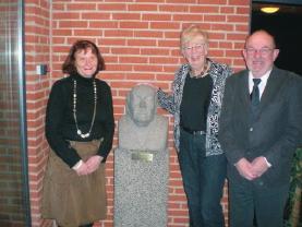 Tre medlemmer af Michael Jensen Fonden ved en statue af