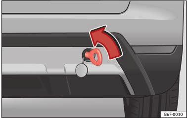 Tag slæbeøjet fra bilens værktøj. Tryk for at frigøre den på afdækningens højre del, så den bliver clipset ud Fig. 105. Skru slæbeøjet helt i mod venstre i pilens retning Fig. 106.