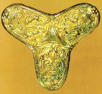 Bagsiden af spændet, som er belagt med hvidmetal, bærer en kraftig nål. Spændets guldbelagte forside er rigt dekoreret med vikingetidens karakteristiske dyreornamentik.