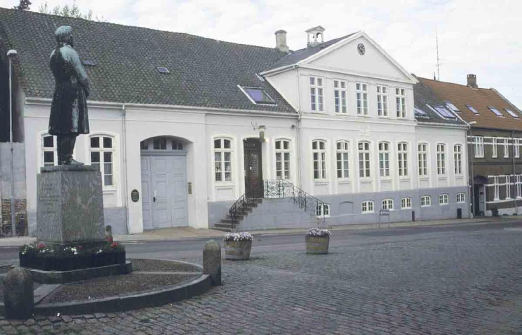 Arkitektur og bebyggelse Forhuset står grundmuret i 14 fag med skiferdækket gavlkvist i fem fag til gården og gaden.
