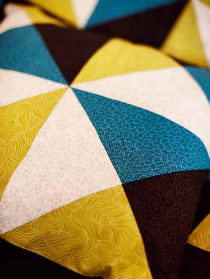 Patchwork Grafik og farver I den smukkeste farvesammensætning får du her et fantastisk sæt bestående af patchworkpuder og -tæppe.