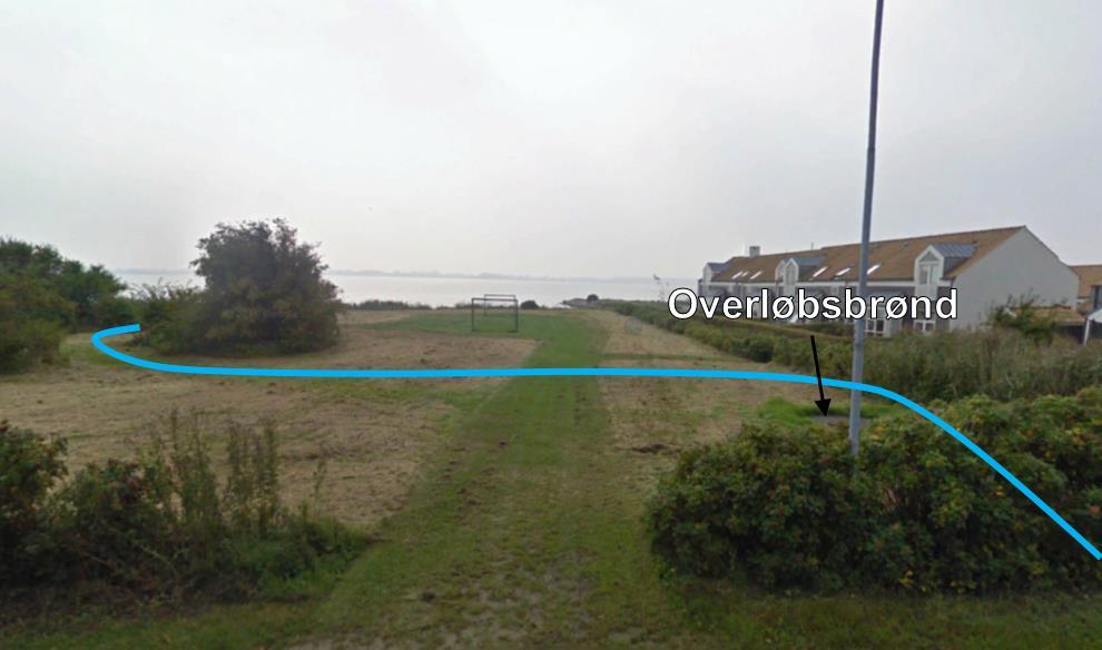På figur. ses arealet hvorover det nye åbne vandløb skal løbe. Til højre i billedet ses de bygninger, der skal sikres ikke bliver påvirket af projektet. Figur.