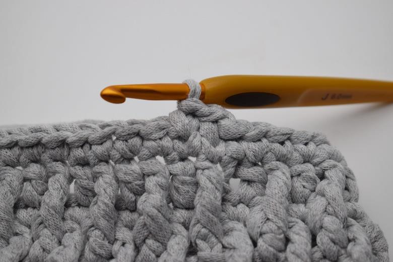 5. Der er nu hæklet endnu en knit stitch. 6. Hækl knit stitch hele vejen rundt og afslut med 1 km. 7. Gentag omgangen så du i alt har 2-3 omgange med knit stitch.